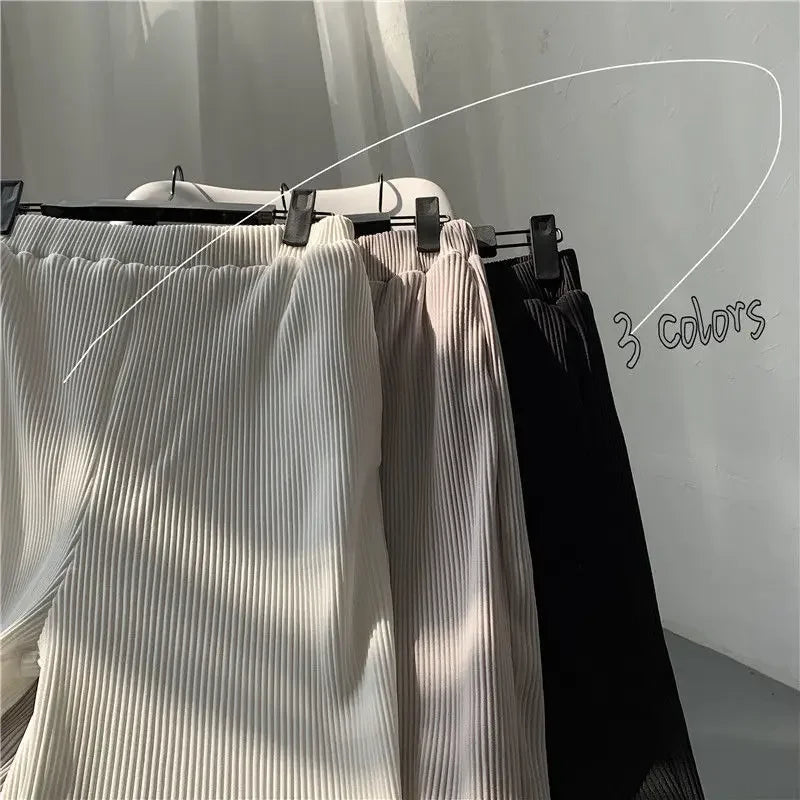 Three pleated pants in white, beige, and black hanging with clips, labeled '3 colors'.