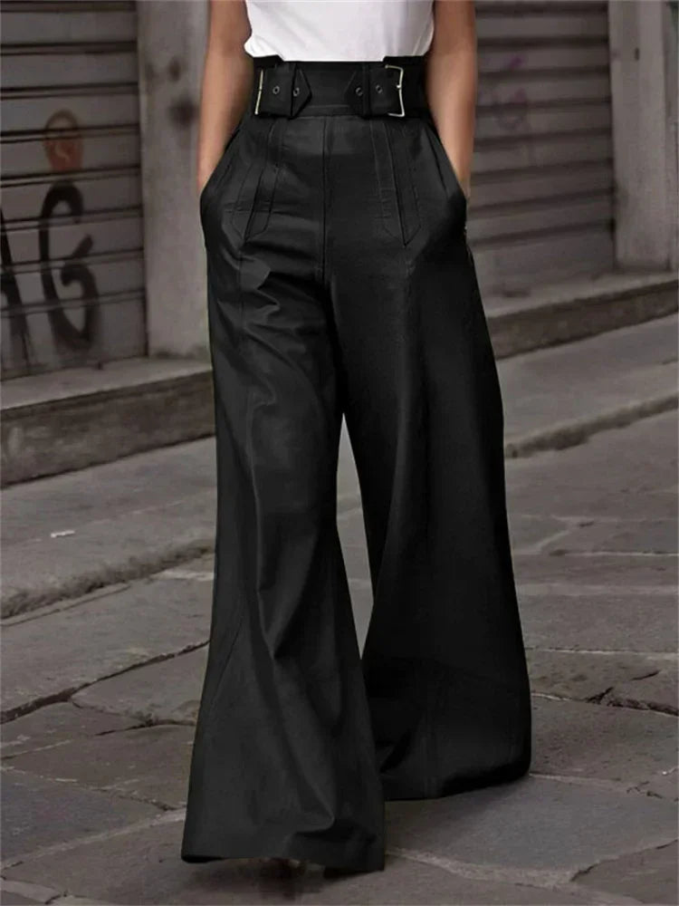 Woman wearing high-waisted black wide-leg pants with belt, urban street background