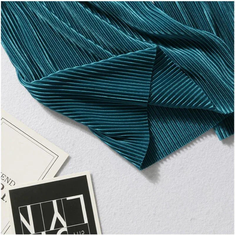 Teal pleated velvet fabric on white background with modern cards, textile texture closeup