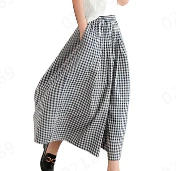 Woman wearing black and white gingham check wide-leg skirt, white top, black shoes